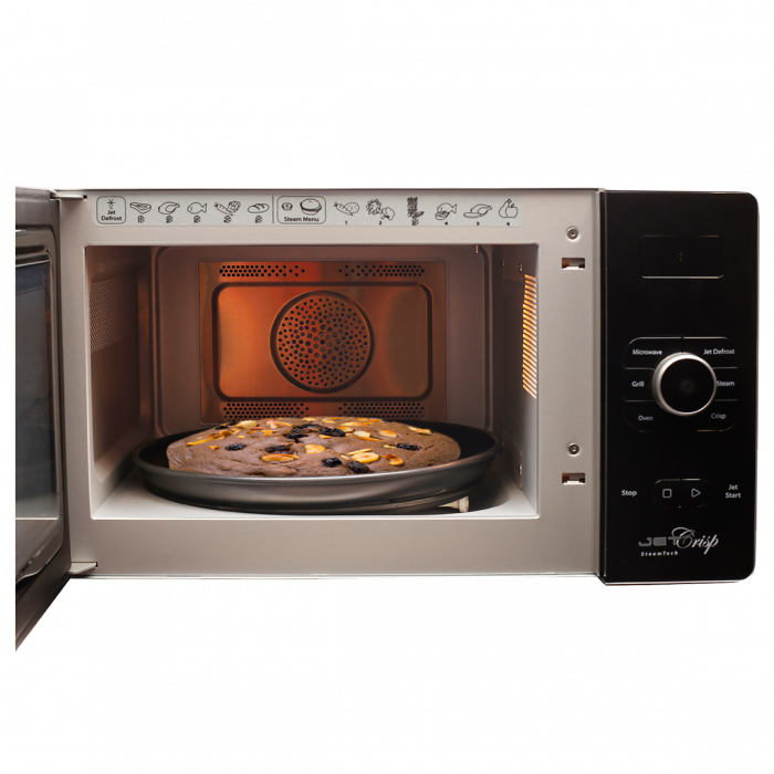 Stainless Microwave Oven Cooking A Meal With Interior Light PNG Photo