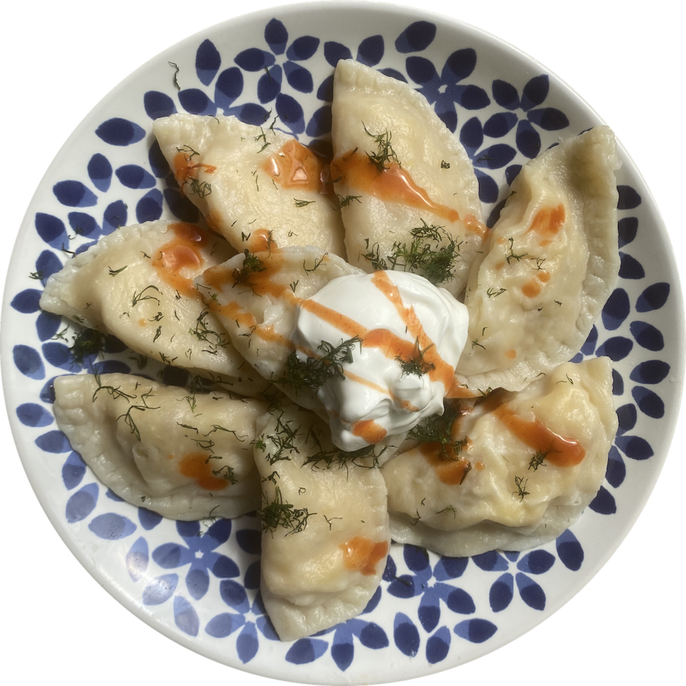 Pierogi with Sour Cream and Fresh Parsley on Blue Patterned Plate PNG Image
